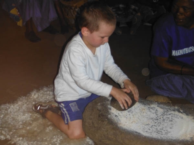 Learning how to grind millet with a grind stone, Lesotho