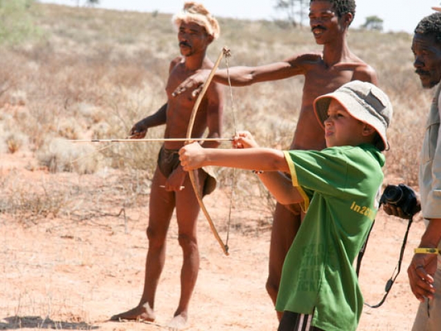 Kai learning how to hunt with a bow and arrow from the #Khomani San in the Kalahari, South Africa