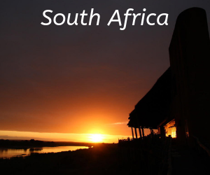 A thatched safari lodge silhouetted against the setting sun in South Africa