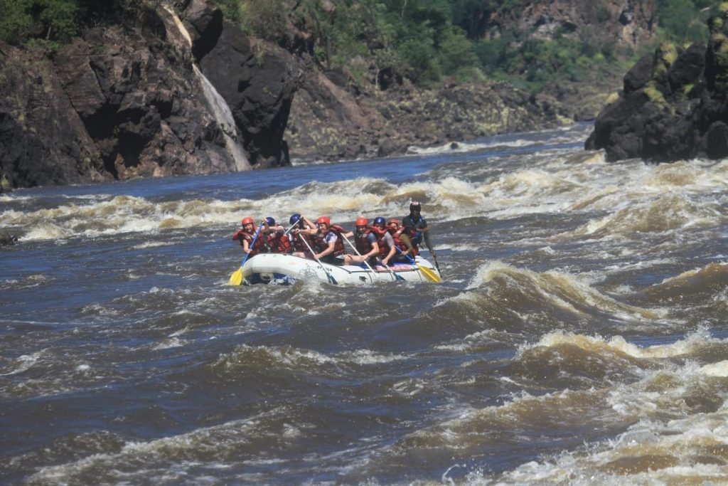 A determined crew with their paddles synchronised to get through a rapid
