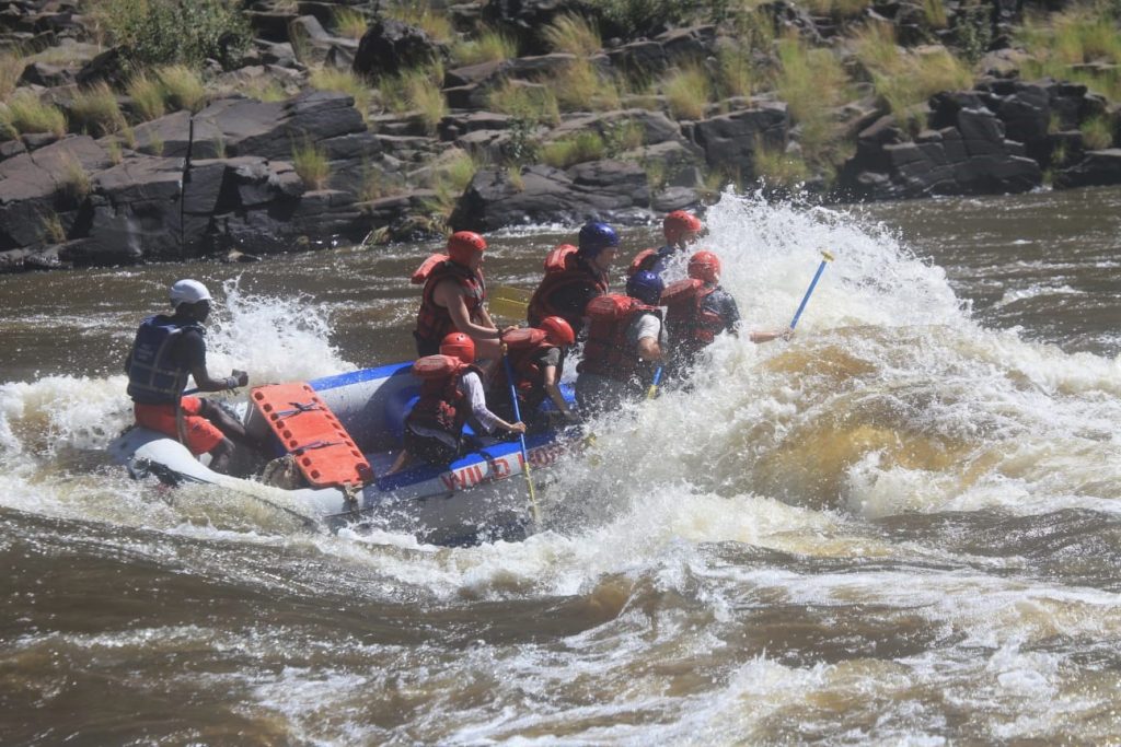 Everyone regrouping as the raft ploughs trhough another wave, whitewater rafting Victoria Falls