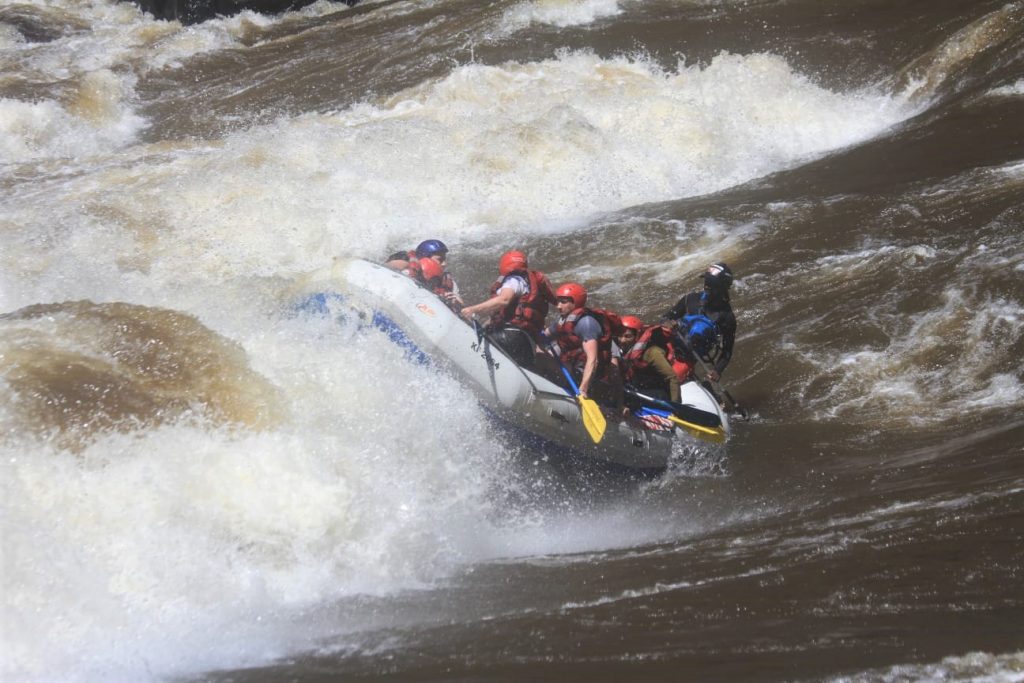 The whitewater raft being lifted at the front by a rapid in the Zambezi River