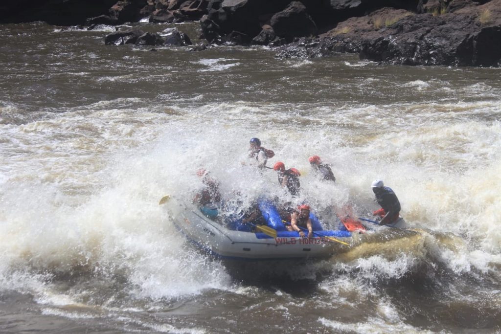 Everyone getting very wet in the raft as it is covered in water