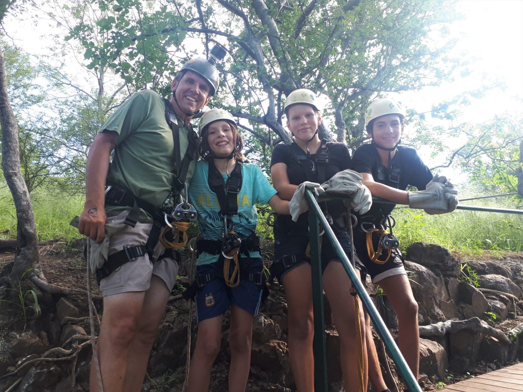 A family photo of everyone standing in their gear with big smiles on their faces.