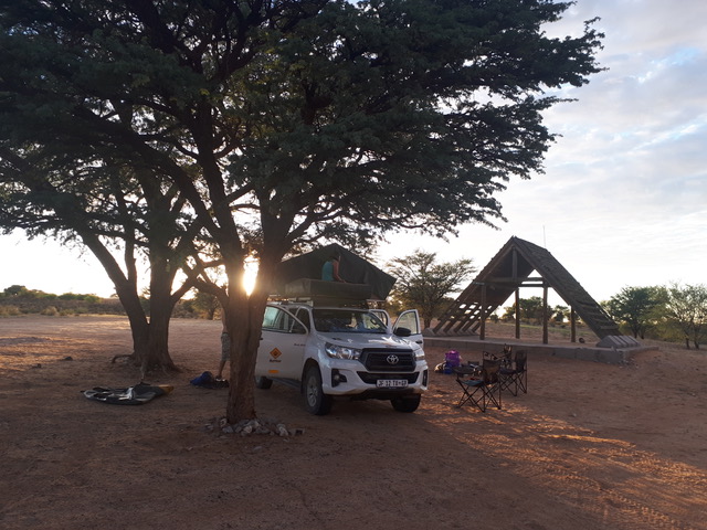 A image of a hired 4WD set up as the sun sets with its roof top tent in a campsite in Botswana