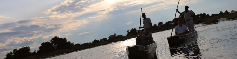 Two mokoros gliding through the calm waters of the Okavango Delta, Botswana